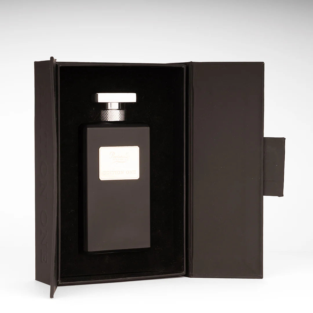 Black perfume bottle with silver cap in an open black box on a white background
