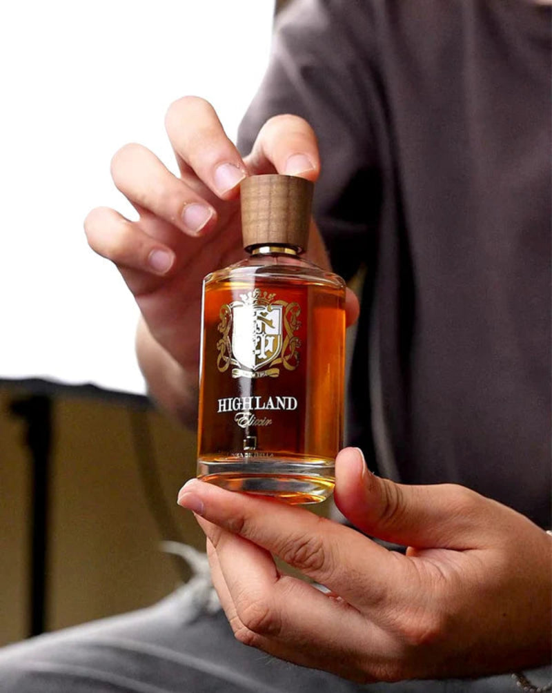 Person holding a bottle of Highland brand whiskey