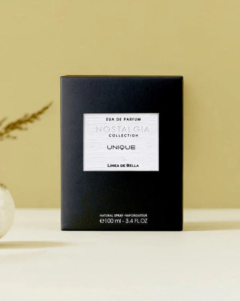 Black perfume box with white label on a beige background